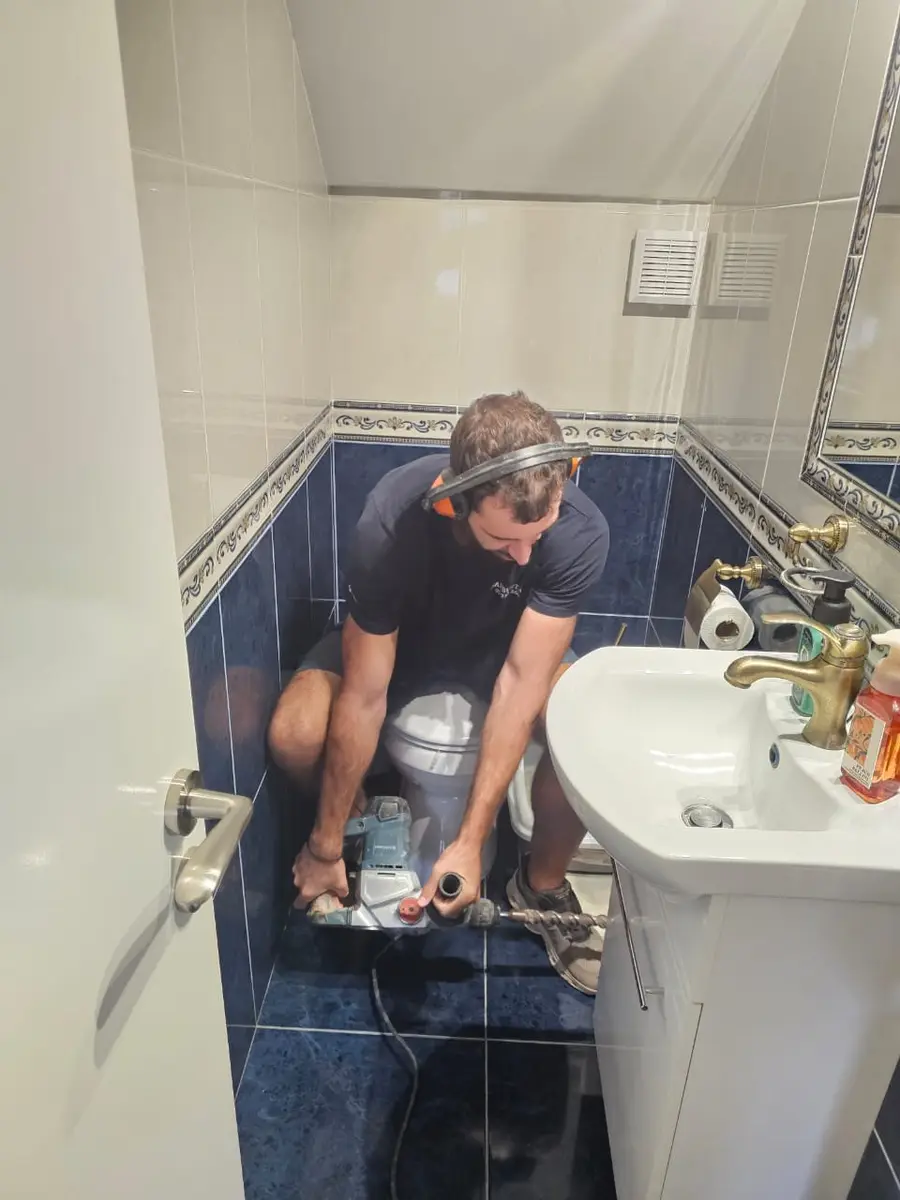 LeakBusters technician investigating a hidden bathroom leak
